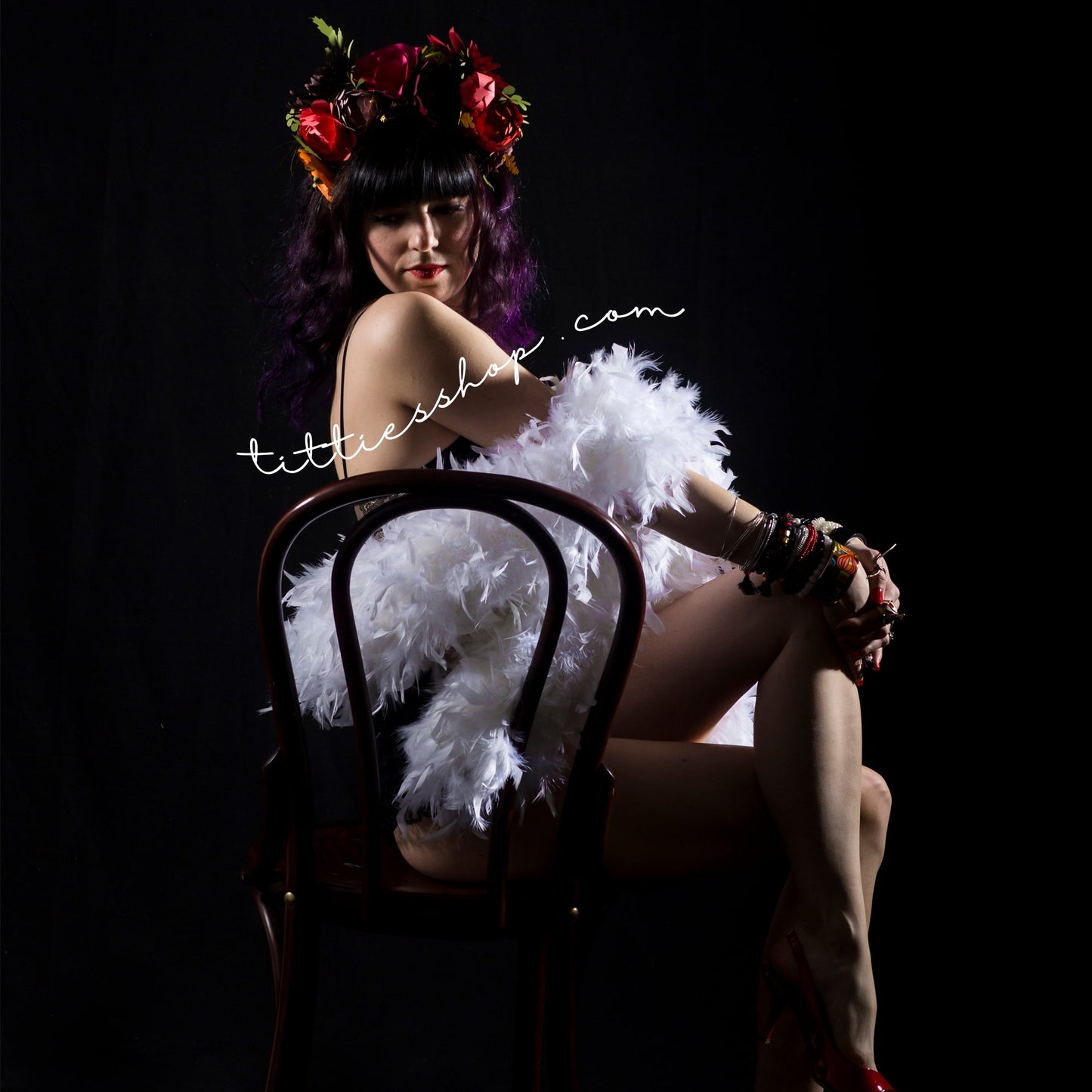 The owner of tittiesshop on a lingerie photoshoot with a white feather boa and her colourful flower crown