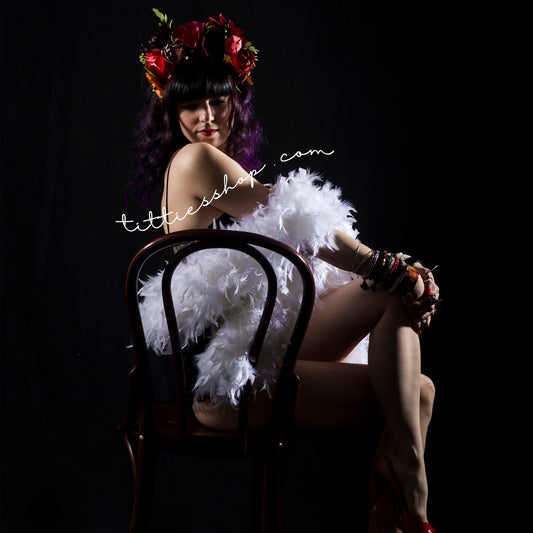 The owner of tittiesshop on a lingerie photoshoot with a white feather boa and her colourful flower crown