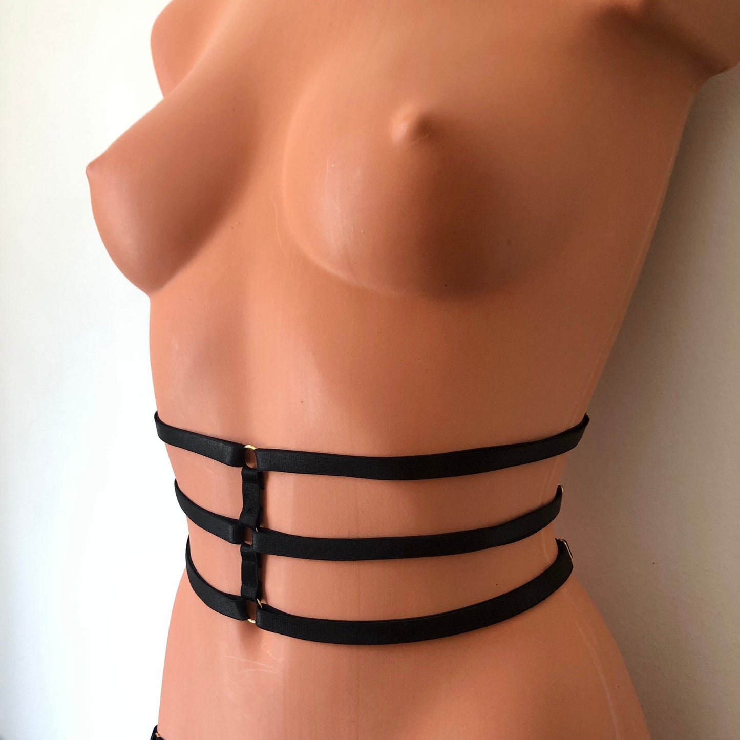 Black elastic waist cage harness on a mannequin - front diagonal