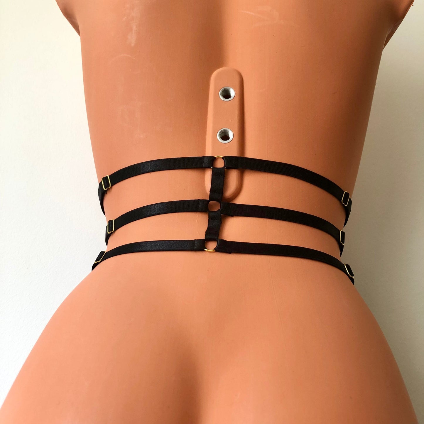 Black elastic waist cage harness on a mannequin - back