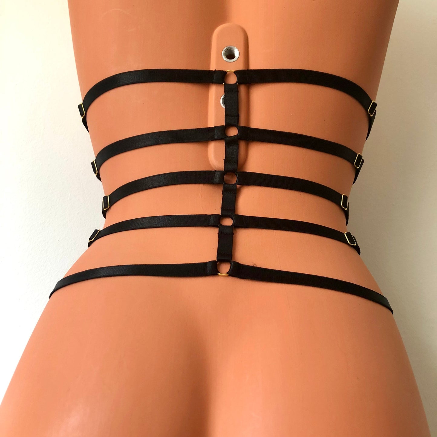 Black elastic waist cage harness on a mannequin - back