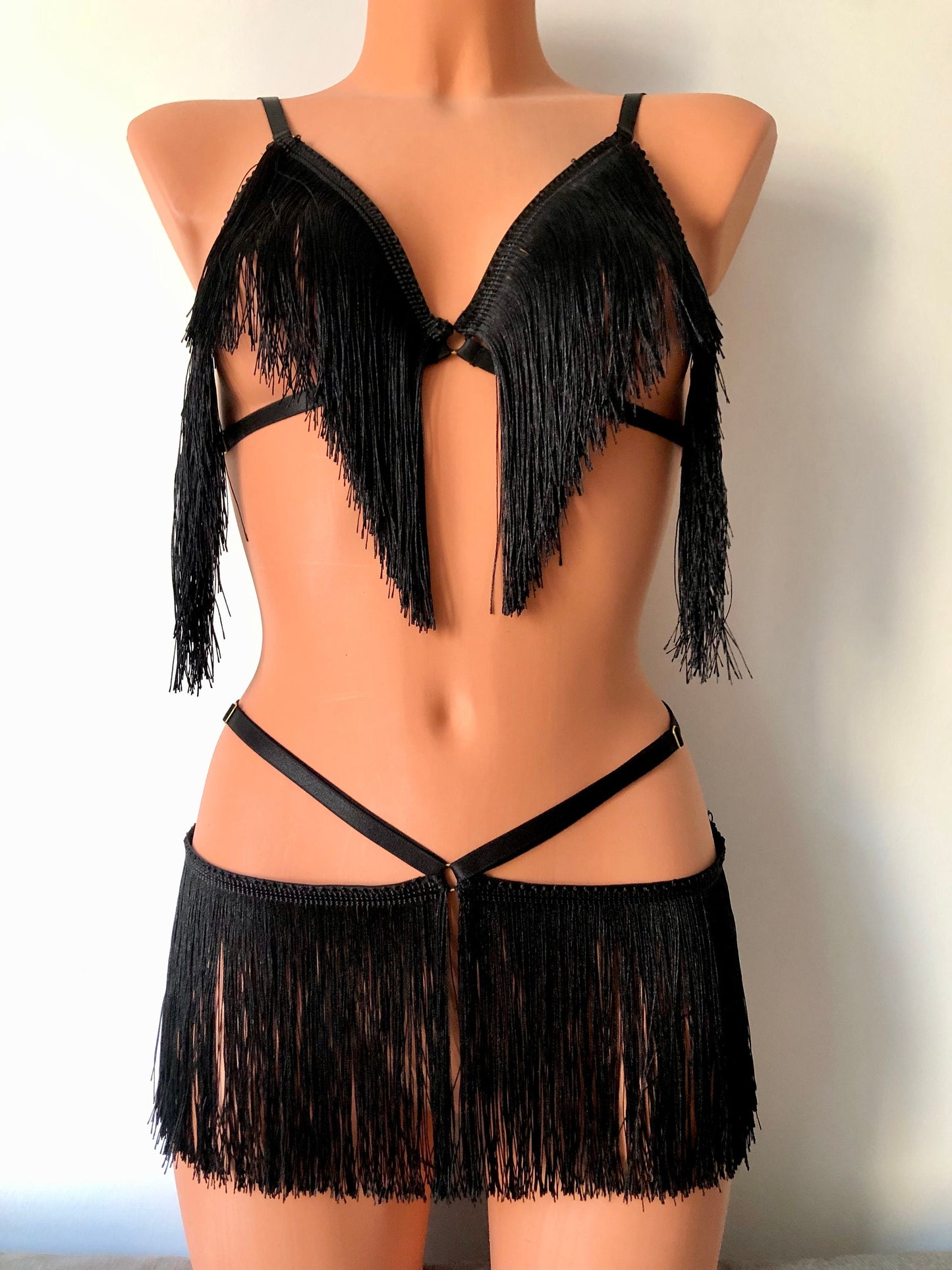 Black shimmy fringe waist harness belt skirt and fringe cupless bra set on a mannequin - front