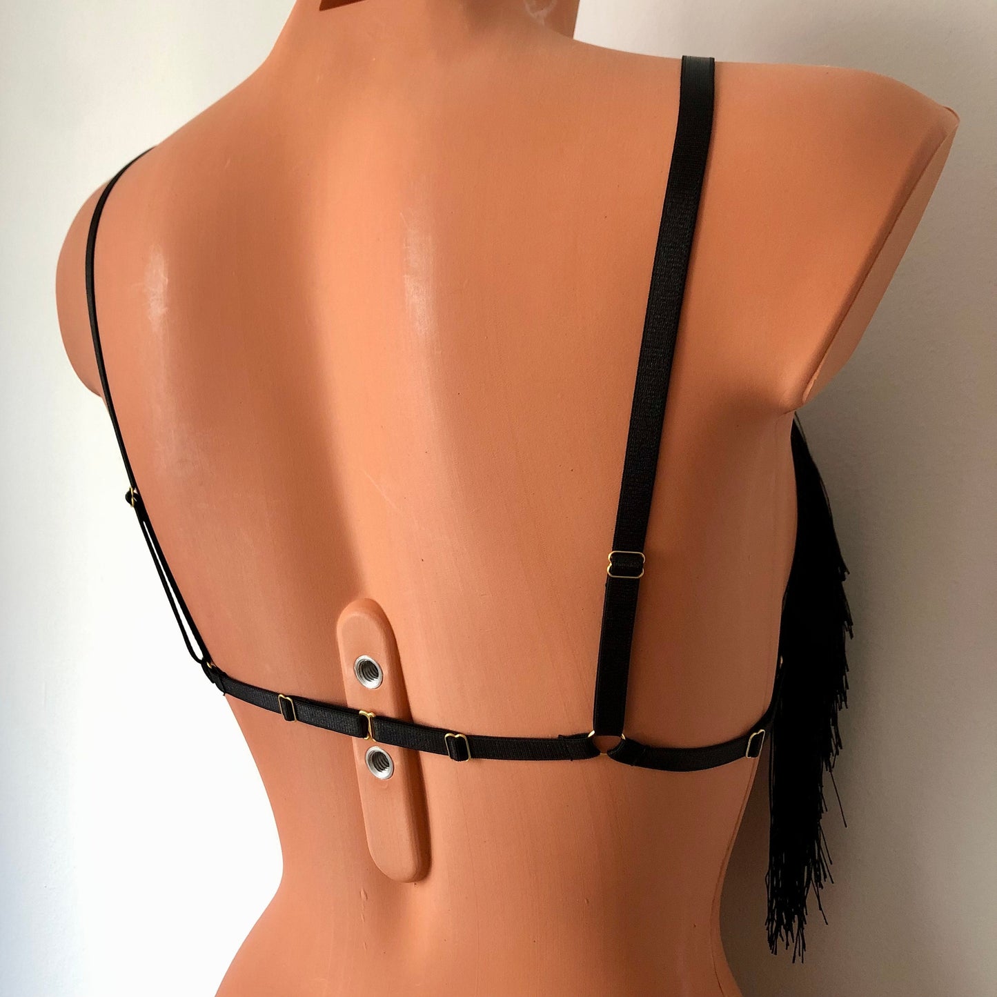Black shimmy fringe cupless bra on a mannequin - back diagonal