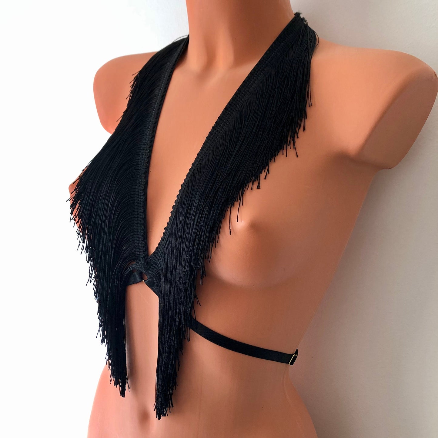 Black shimmy fringe chest harness on a mannequin - front diagonal