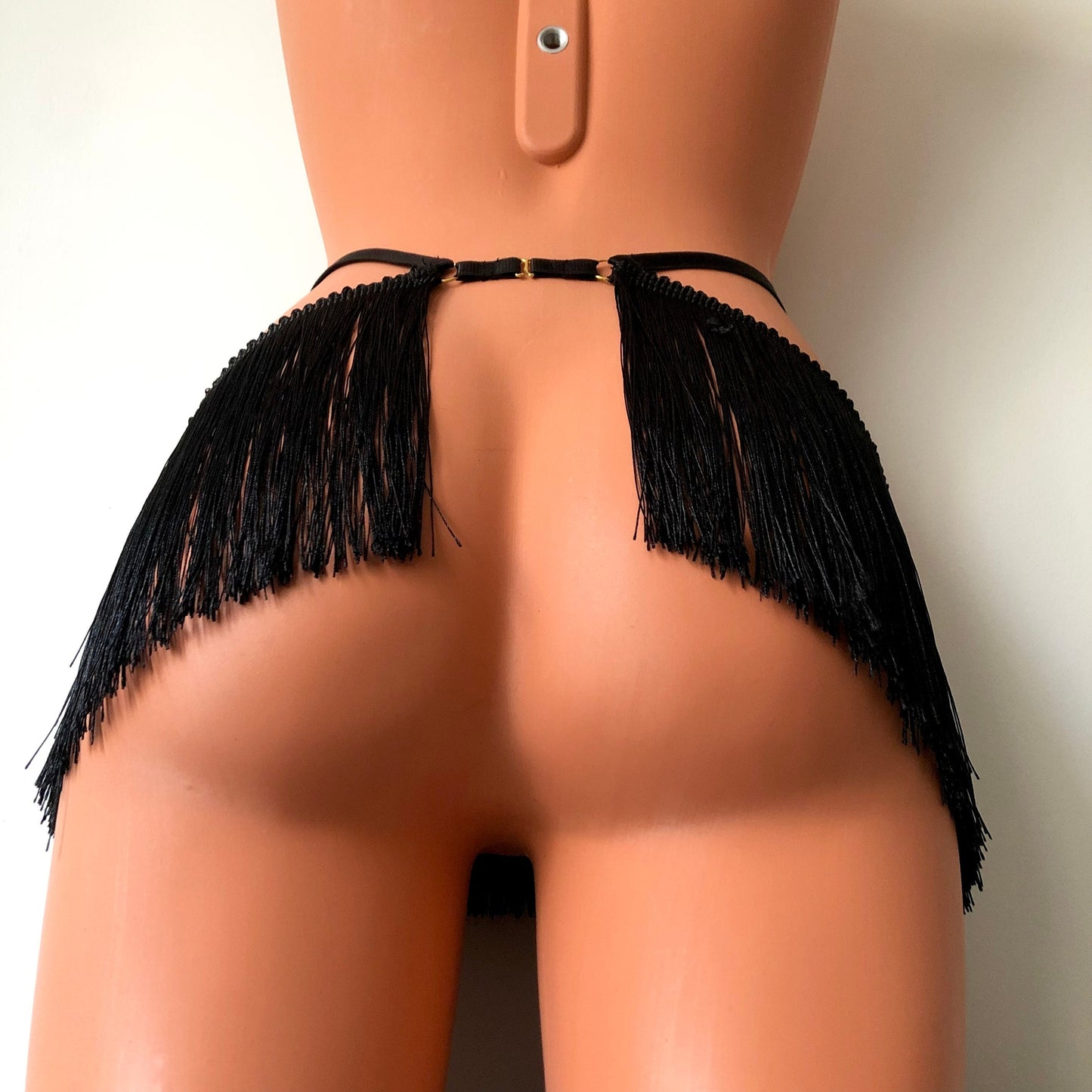 Black shimmy fringe waist harness belt skirt on a mannequin - back