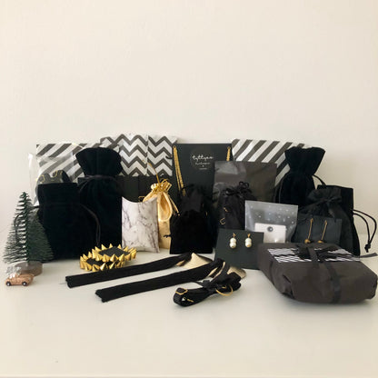 A collection of black velvet and black and white striped sachets, pouches and boxes