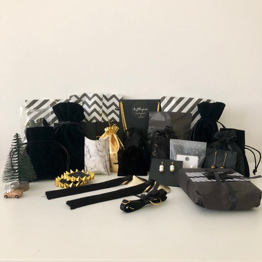 A collection of black velvet and black and white striped sachets, pouches and boxes