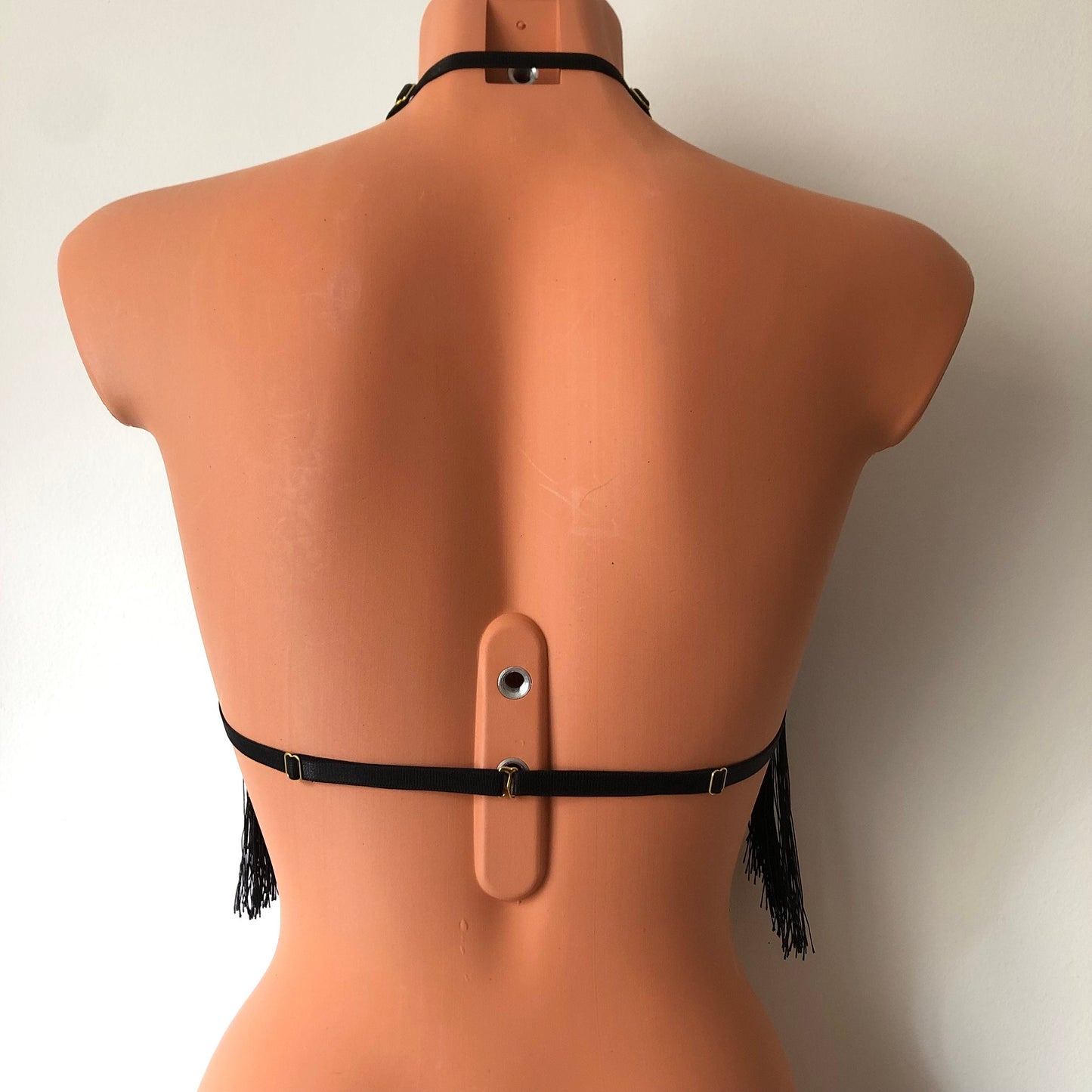 Black shimmy fringe twisted neck halter bra on a mannequin - back